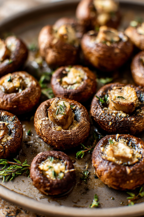 A plate of mushrooms with cheese and herbs.