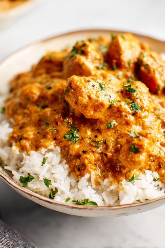 A bowl of rice with a spoonful of Achiote Chicken.