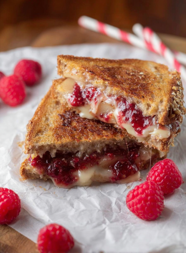 A sandwich with raspberries on top.