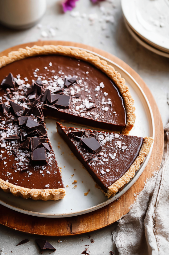 A slice of chocolate cake with chocolate chips on top.