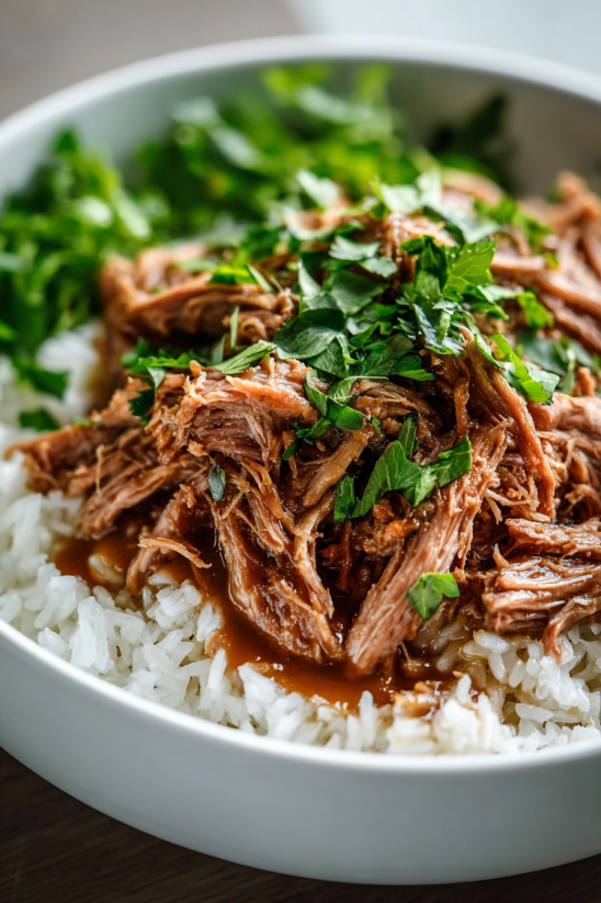 A bowl of rice with meat on top.