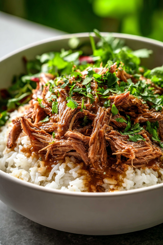 A bowl of rice with meat and vegetables.