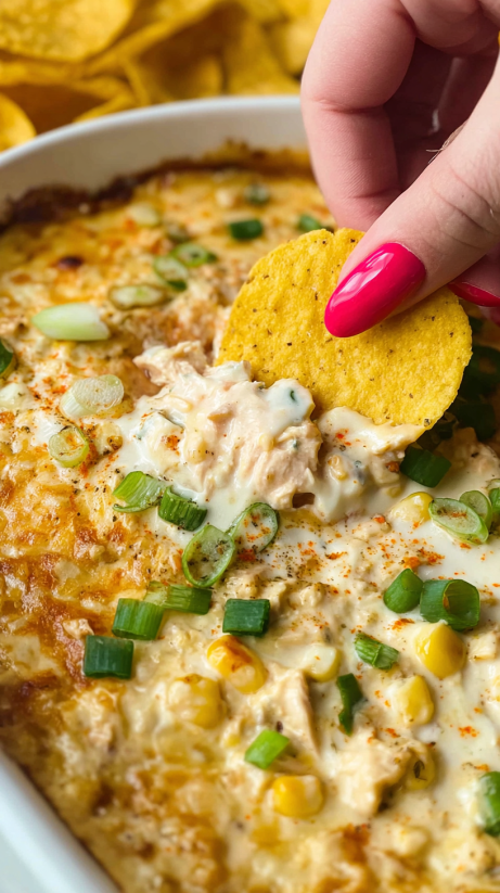 A person is eating a chicken dish with chips.