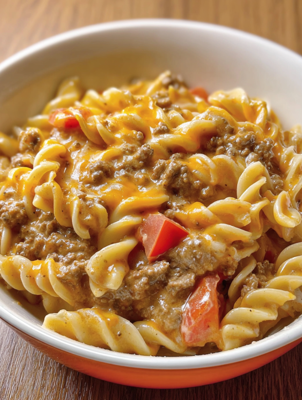 A bowl of pasta with meat and tomatoes.