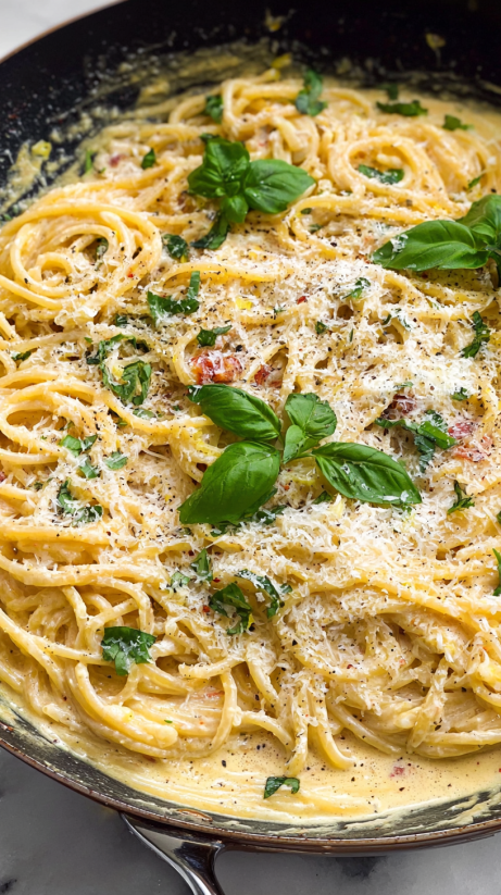 A bowl of pasta with spinach and cheese.