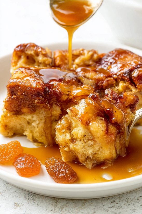 A slice of donut bread pudding with syrup drizzled over it.
