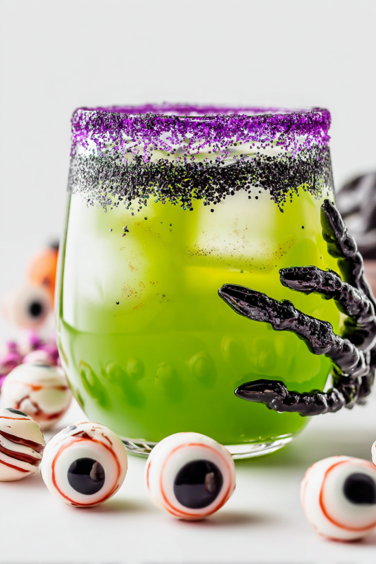 A green drink with a black hand holding it.