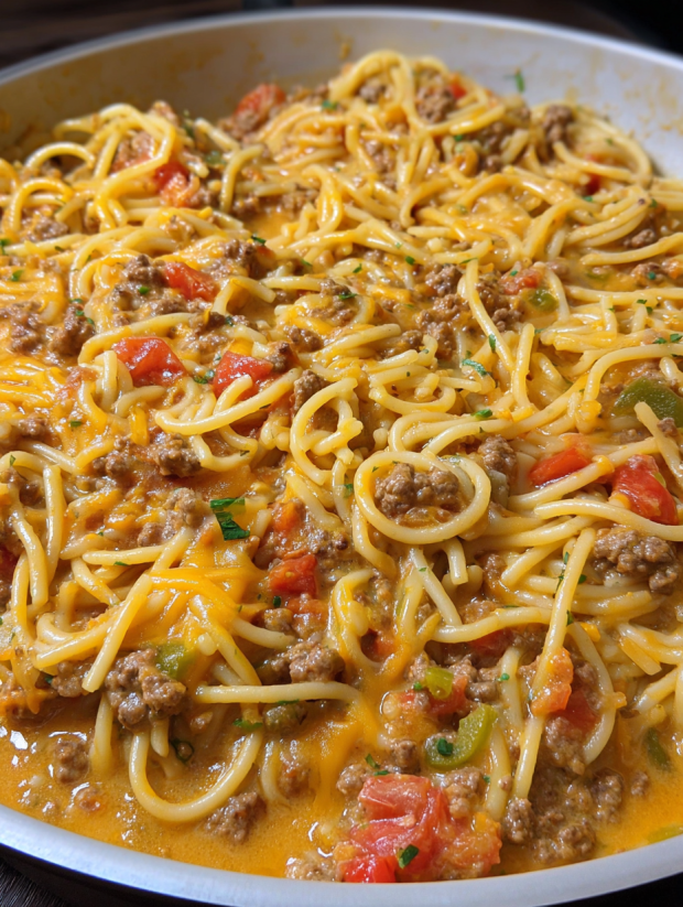 A bowl of spaghetti with meat and tomatoes.