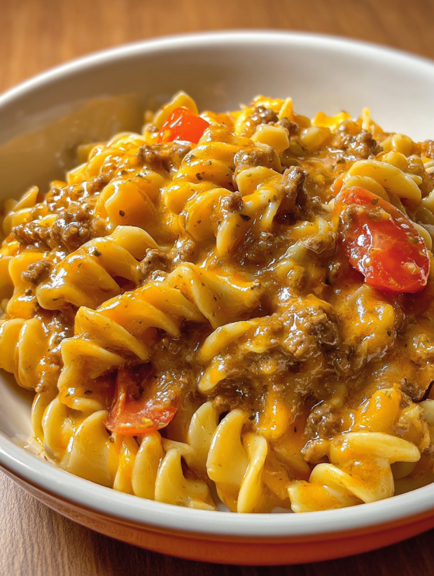 A bowl of pasta with meat and tomatoes.