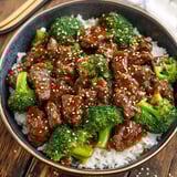 A bowl of beef and broccoli with rice.