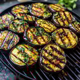 Grilled eggplant on a grill.