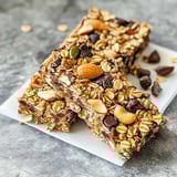 A plate of granola bars with nuts and chocolate.