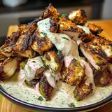 A plate of chicken shawarma with creamy garlic sauce.