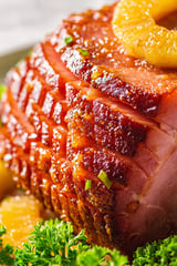 A close up of a piece of meat with a green herb on it.