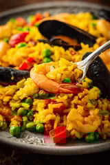 A fork is picking up shrimp and rice.