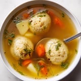 A bowl of soup with meatballs and carrots.