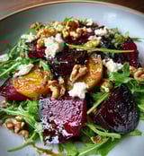 A plate of food with a salad and a nut.