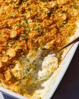 A close up of a casserole dish with a spoon in it.