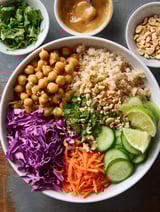 A bowl of food with a variety of vegetables and nuts.