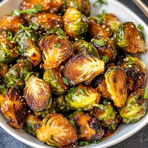 A bowl of Brussels sprouts with a sweet and sour sauce.