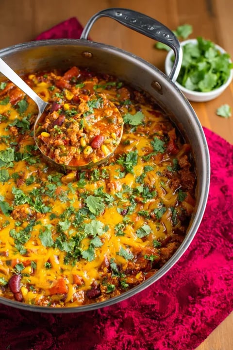 A bowl of chili with a spoon in it.